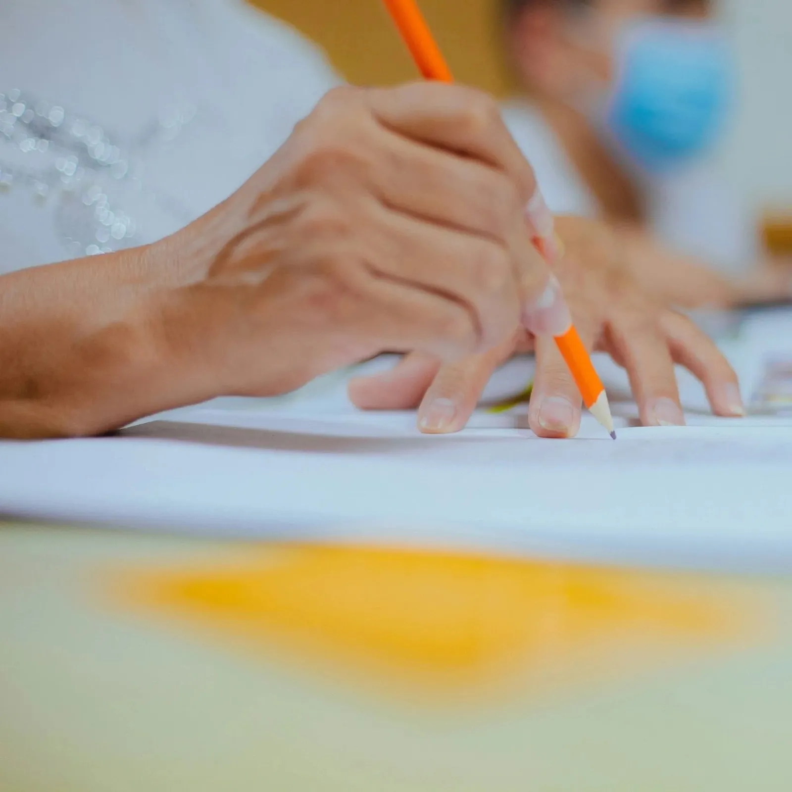 Hands writing during an English learning class