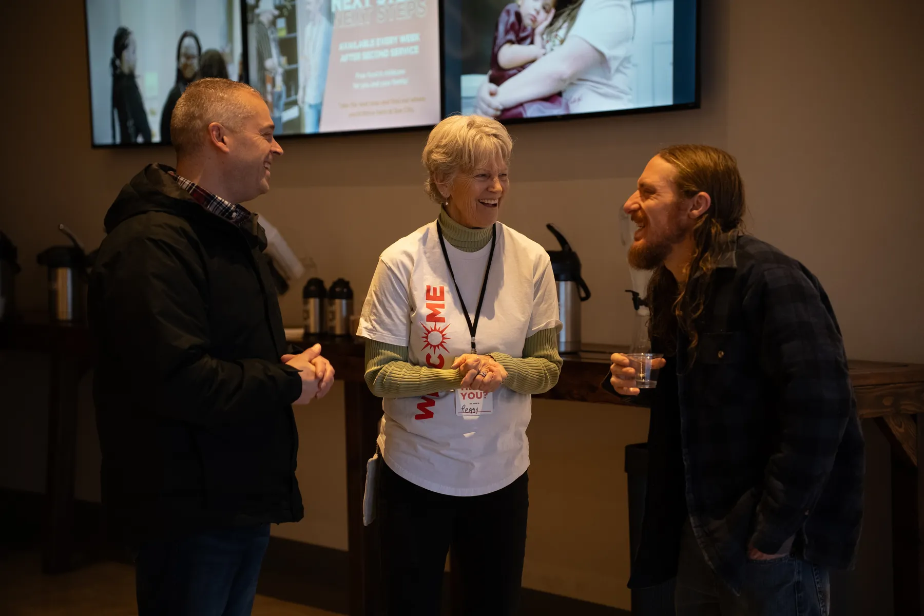 A welcome team member laughing with guests in the lobby