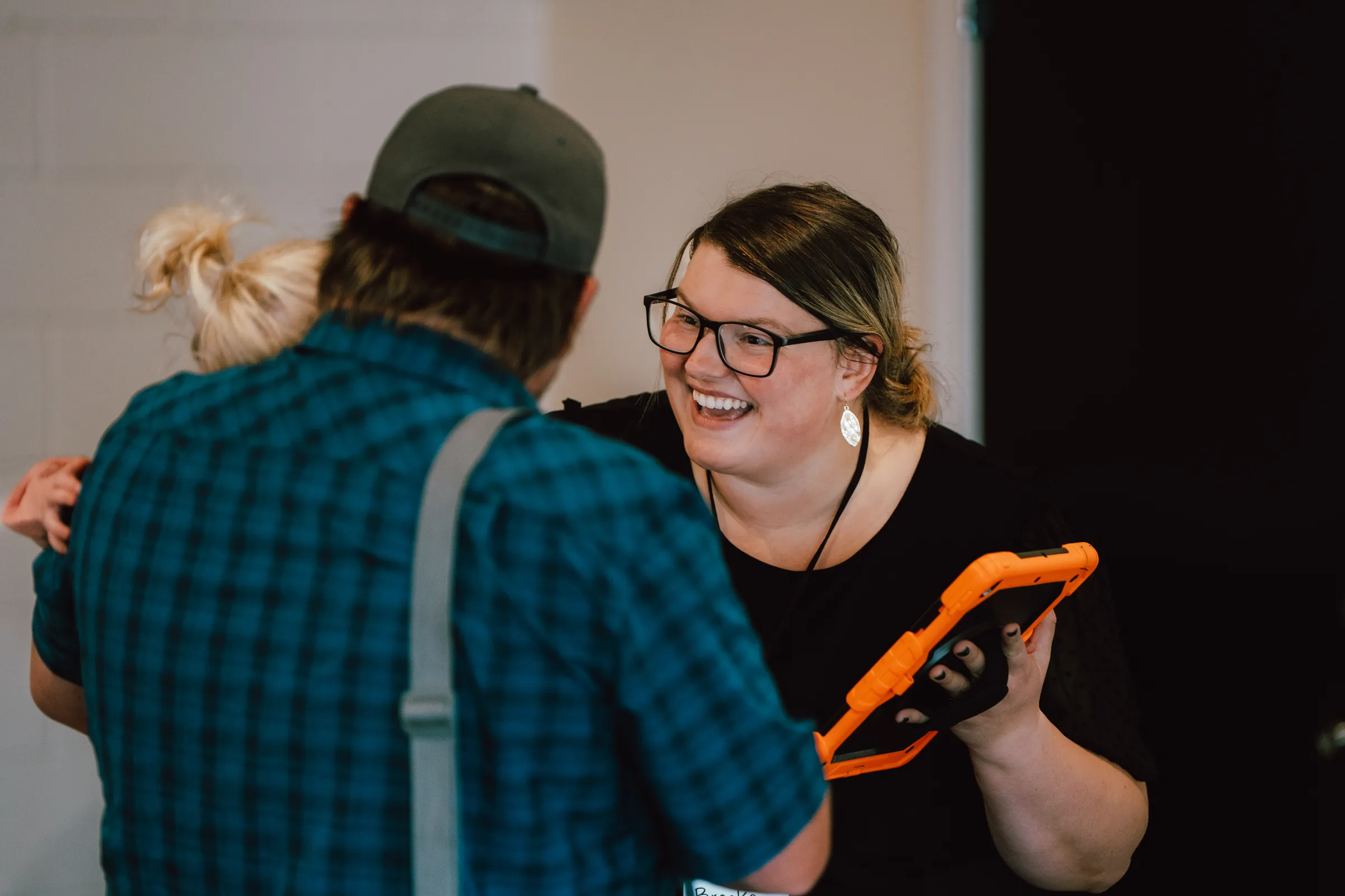 A greeter laughing with a guest at Sun City Church